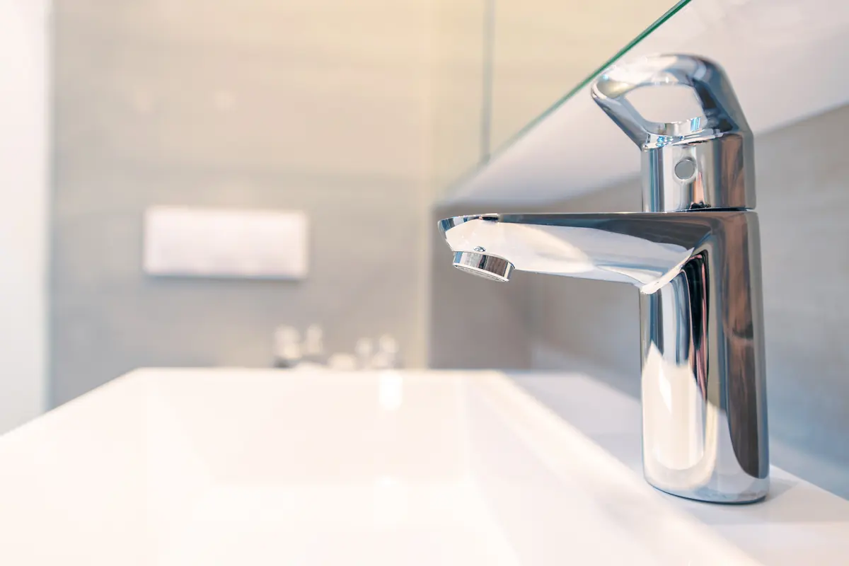 Modern chrome single-handle bathroom faucet on a white vanity sink